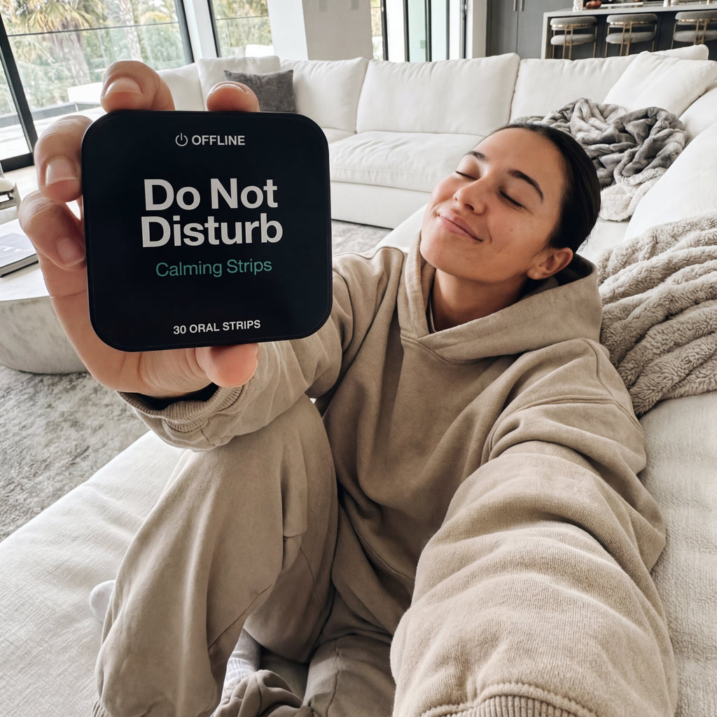 Woman sitting on a couch holding a 'Do Not Disturb' sign in a modern living room.