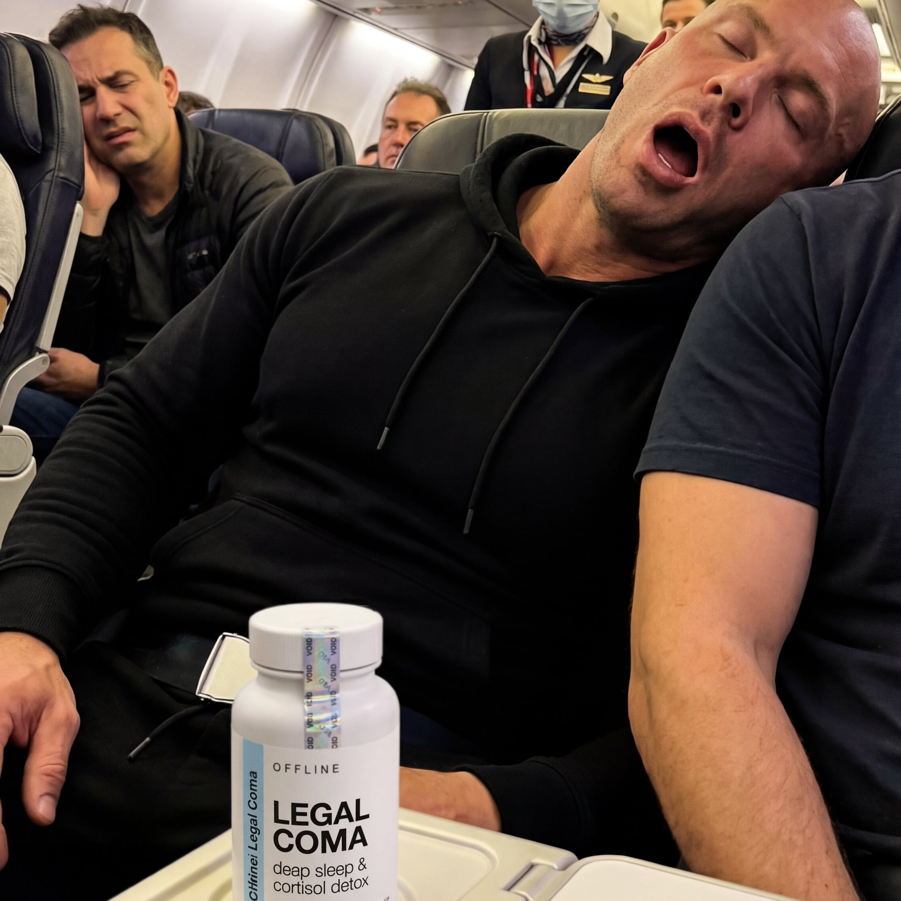 Man sleeping on an airplane with a bottle labeled 'Legal Coma' on the tray table.